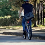 Man met leren zakentas fietsend op een mountainbike